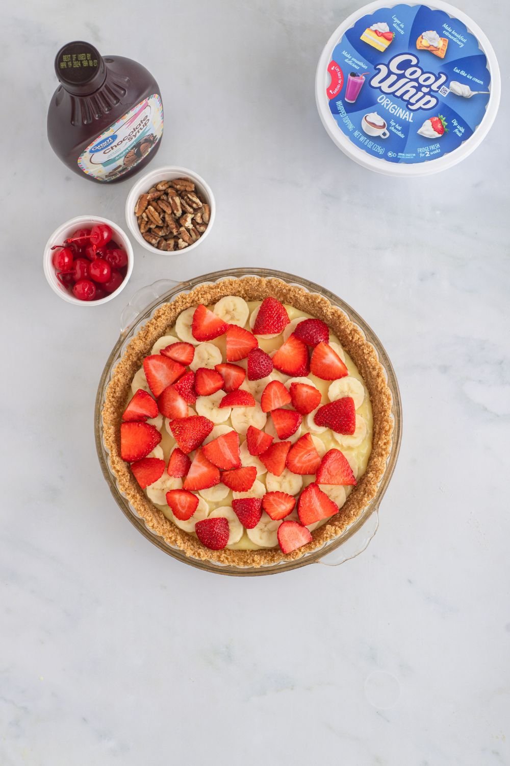 strawberries on top of banana pudding in pie crust 