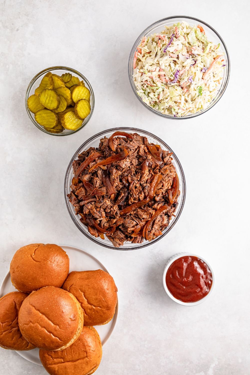 ingredients to make brisket sandwiches on table in single serve bowls 