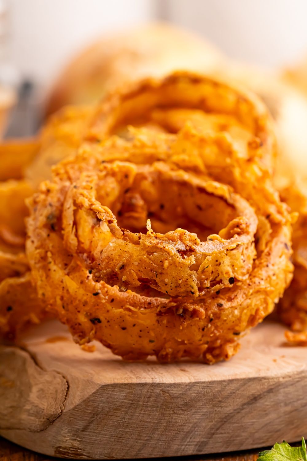 onion rings stacked together on a wooden tray on table