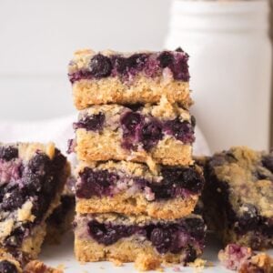 Blueberry Crumb Bars on table and a few stacked on top of each other