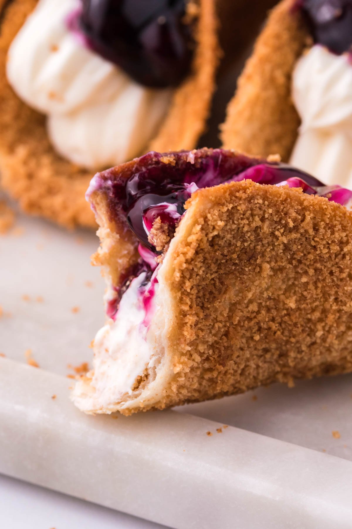 Blueberry Cheesecake Taco with a bite missing 