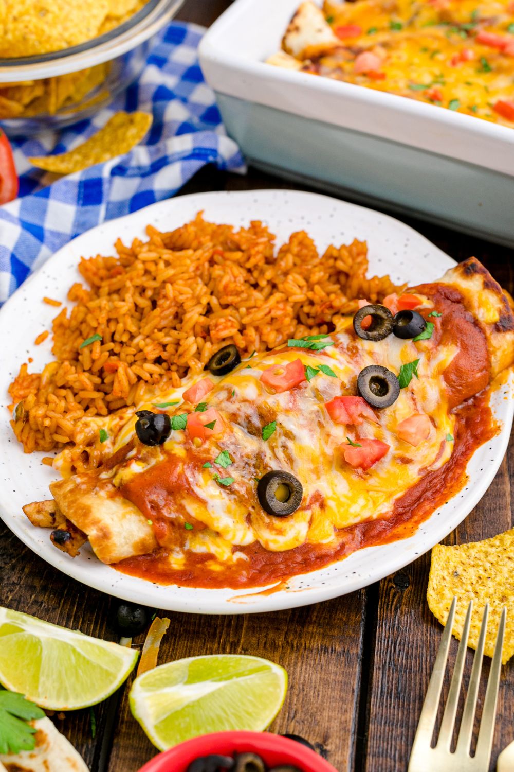 plate with enchilada, rice, and then lime wedges around plate on the table