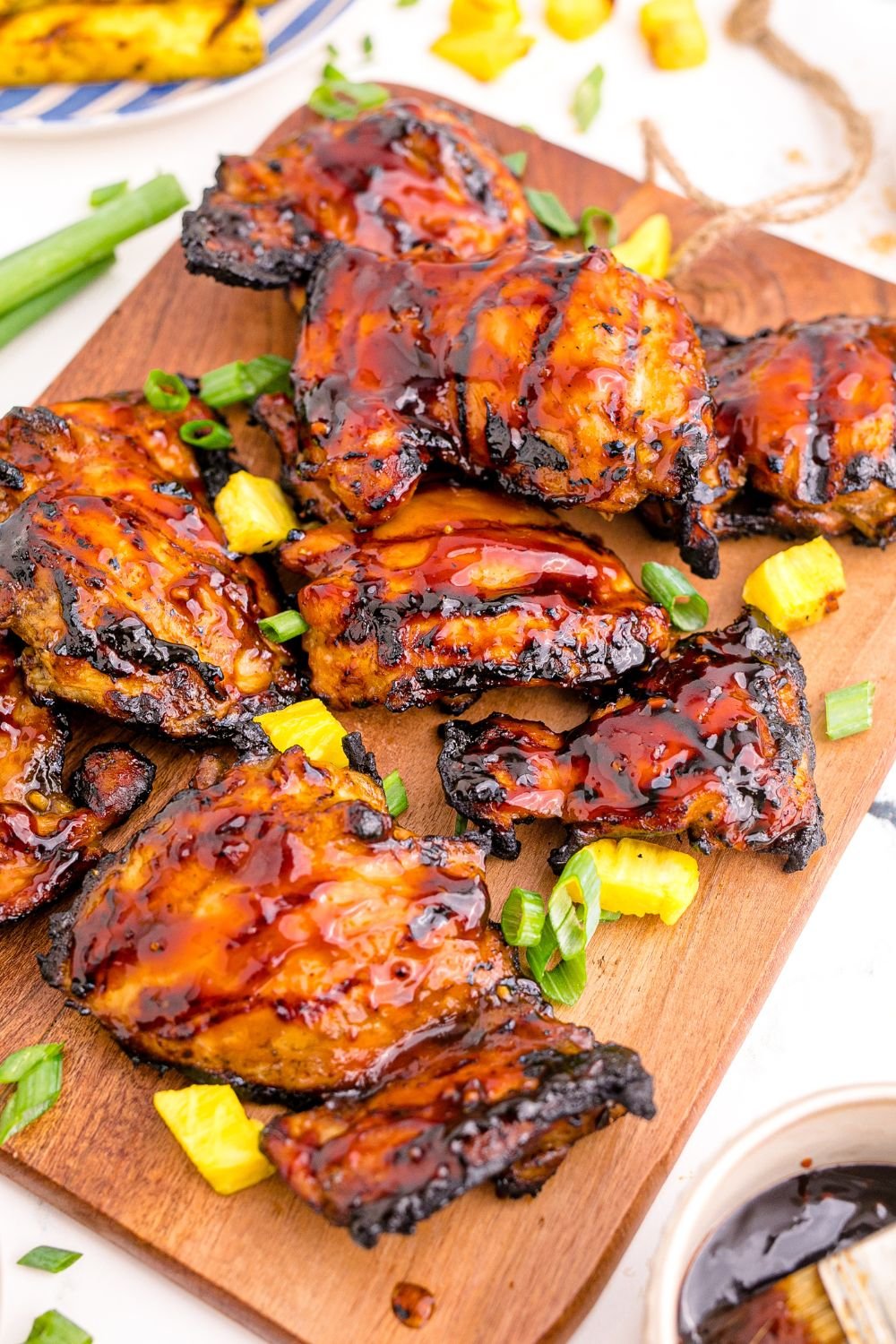 Huli Huli Chicken spread out on table with more glaze in a bowl 