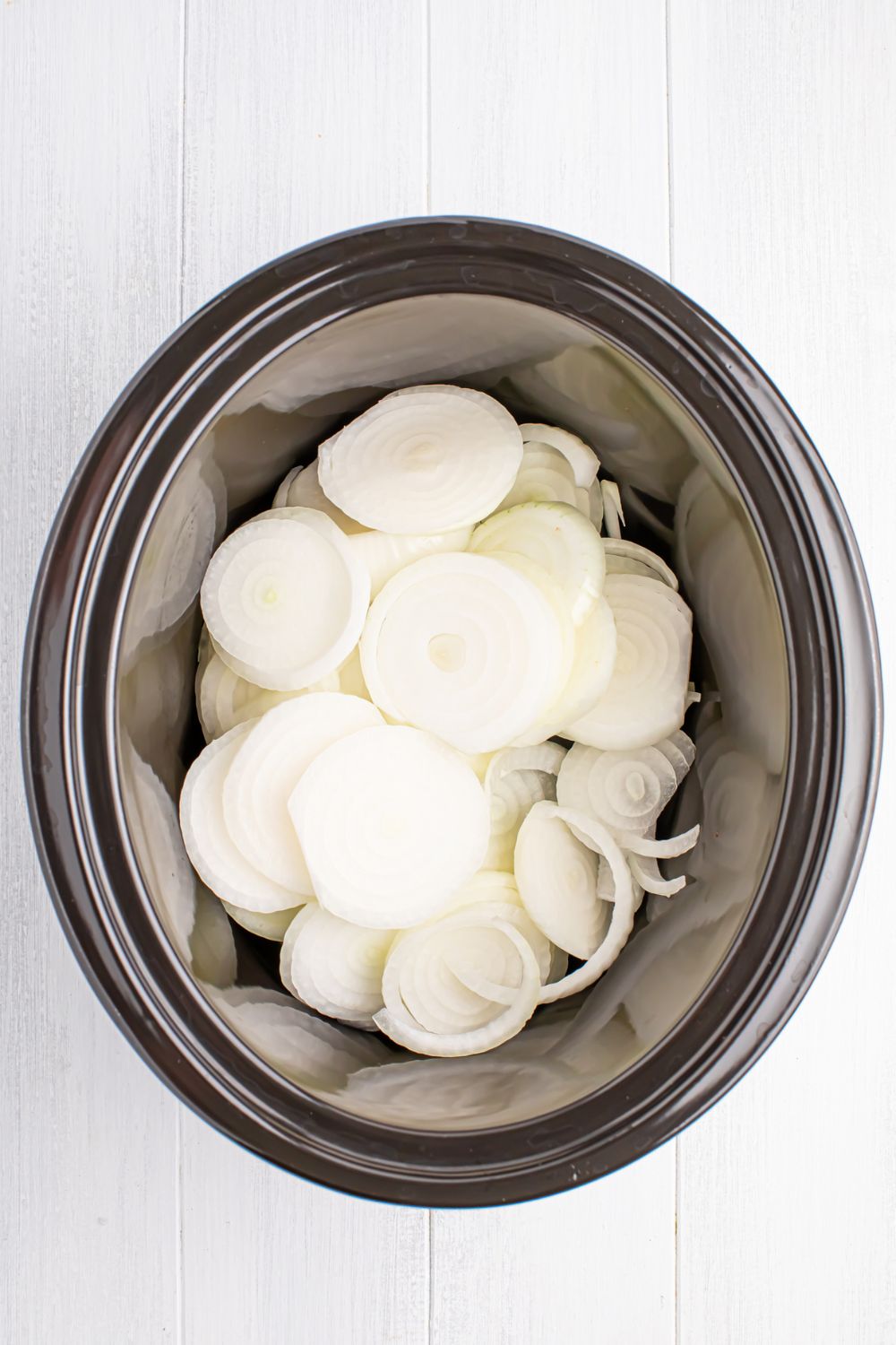 sliced onions in slow cooker for making Crockpot caramelized onions 