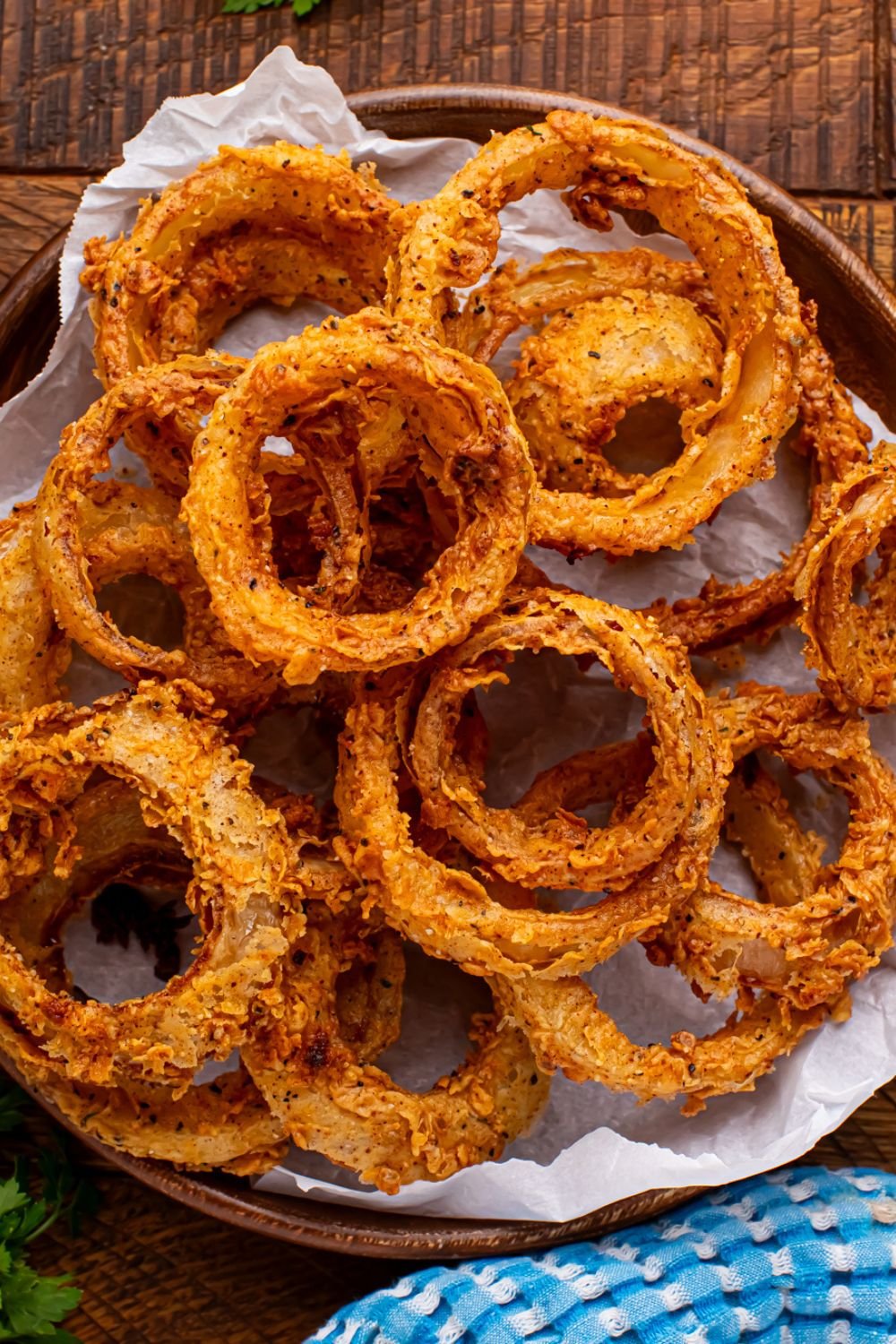 Homemade Deep Fried Onion Rings in a bowl with a towel to the side 