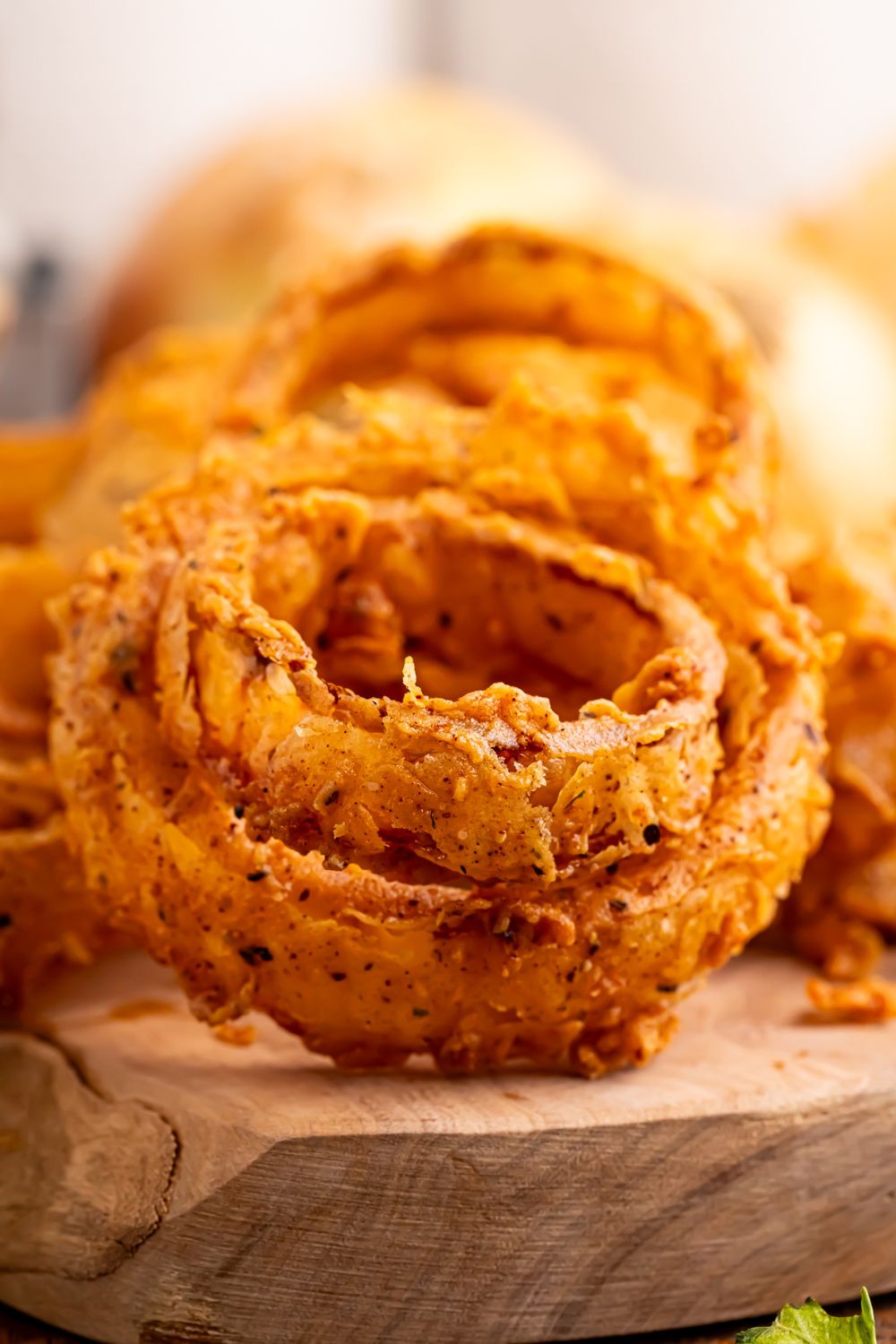 Homemade Deep Fried Onion Rings placed on top of one another on a tray 