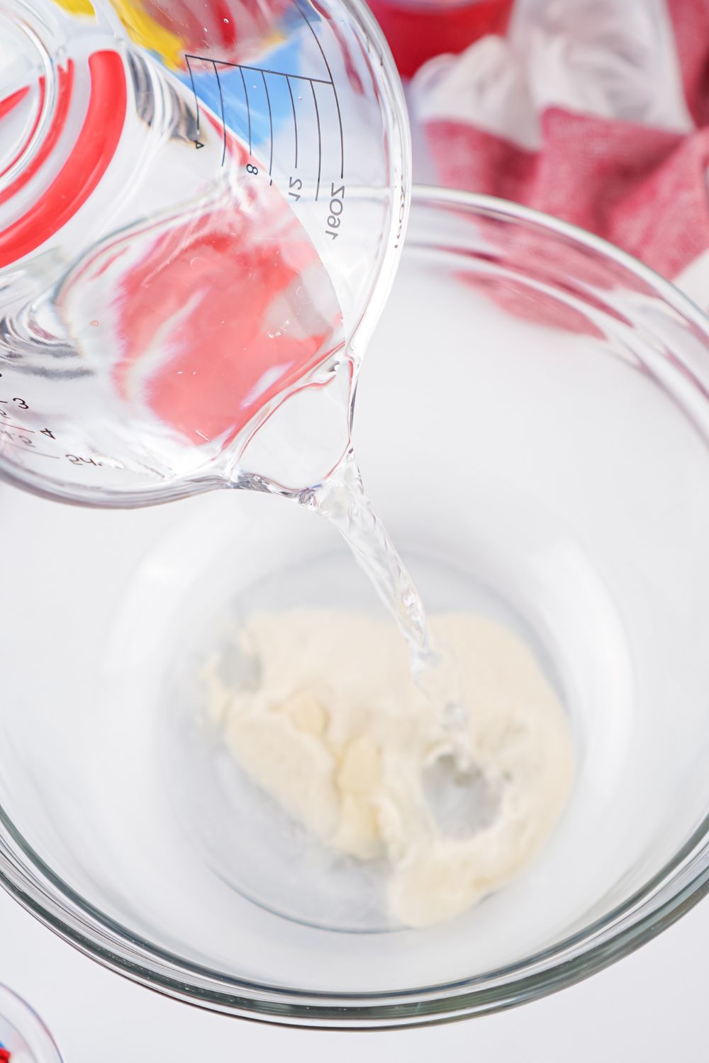 gelatin in a bowl with water being poured on top of it 