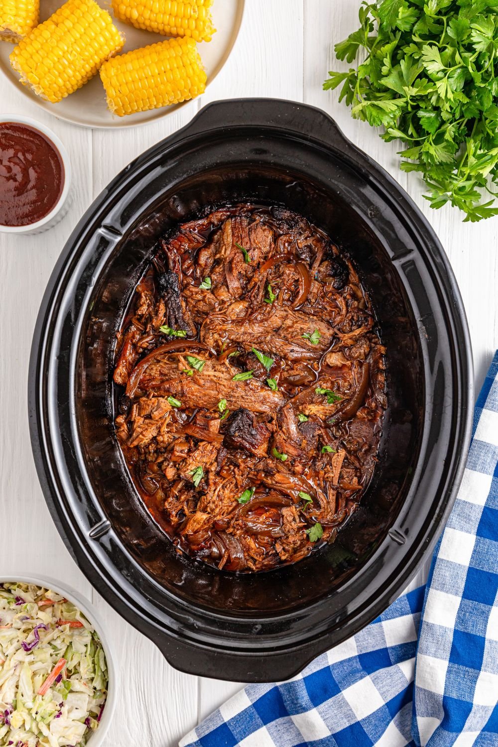Slow Cooker BBQ Brisket in slow cooker with ingredients around the slow cooker 