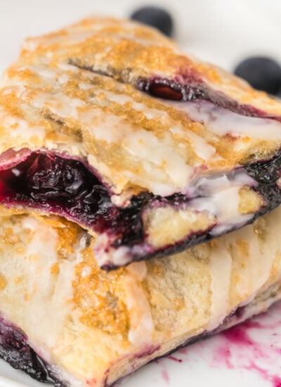 Blueberry Turnovers on plate with fresh blueberries around them on the plate