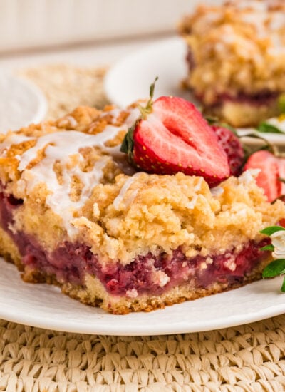 slice of Strawberry Coffee Cake on plate garnished with strawberries and flowers