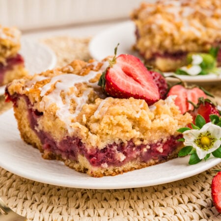 slice of Strawberry Coffee Cake on plate garnished with strawberries and flowers