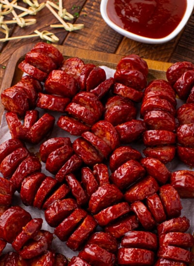 BBQ Hasselback Smoked Sausages on a wooden cutting board
