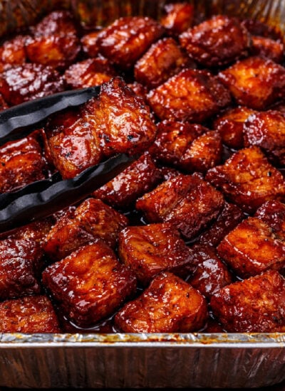 Smoked Pork Belly Burnt Ends in a foil container