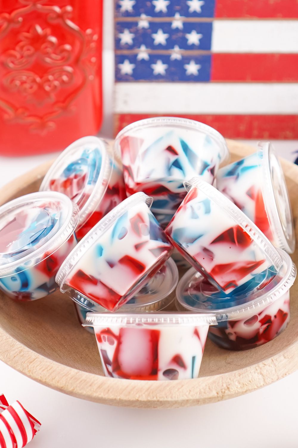 Red White and Blue Jello Shots in containers with lids sitting in bowls 