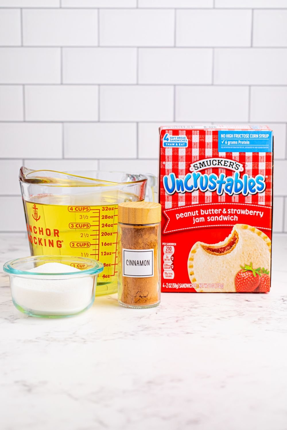 ingredients to make Homemade Strawberry Uncrustables that are fried and coated on table 