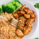 Garlic Butter Chicken Bites on plate with rice and broccoli on side of it