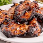 Grilled Chicken Thighs on plate with chicken stacked on top of it