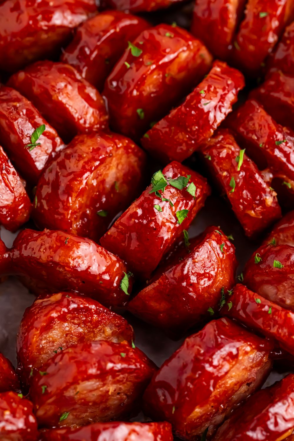 close up of BBQ Hasselback Smoked Sausages with parsley sprinkled on top 