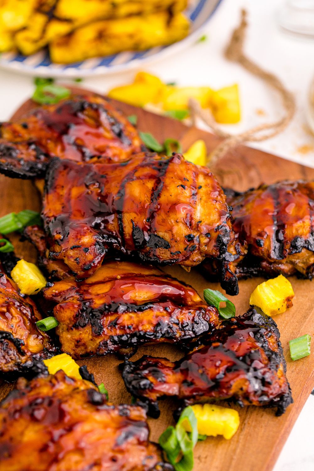 Hawaiian huli huli chicken on cutting board with grilled pineapple on plate 