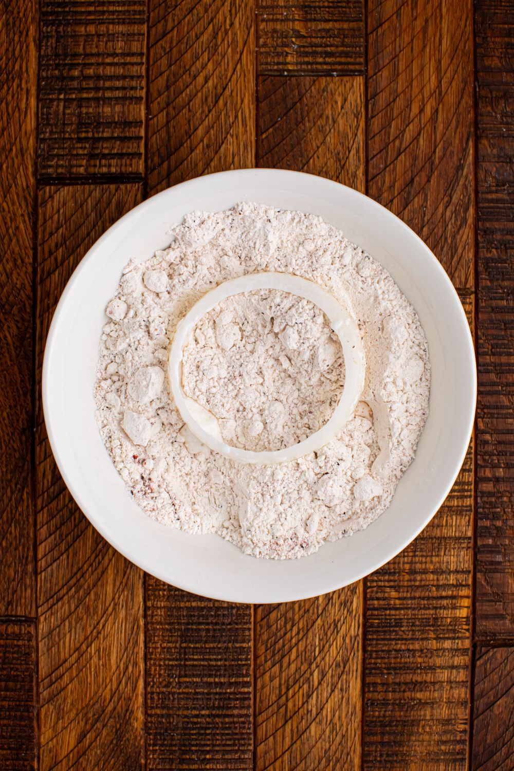 flour mixture in a bowl with onion  on top of flour 