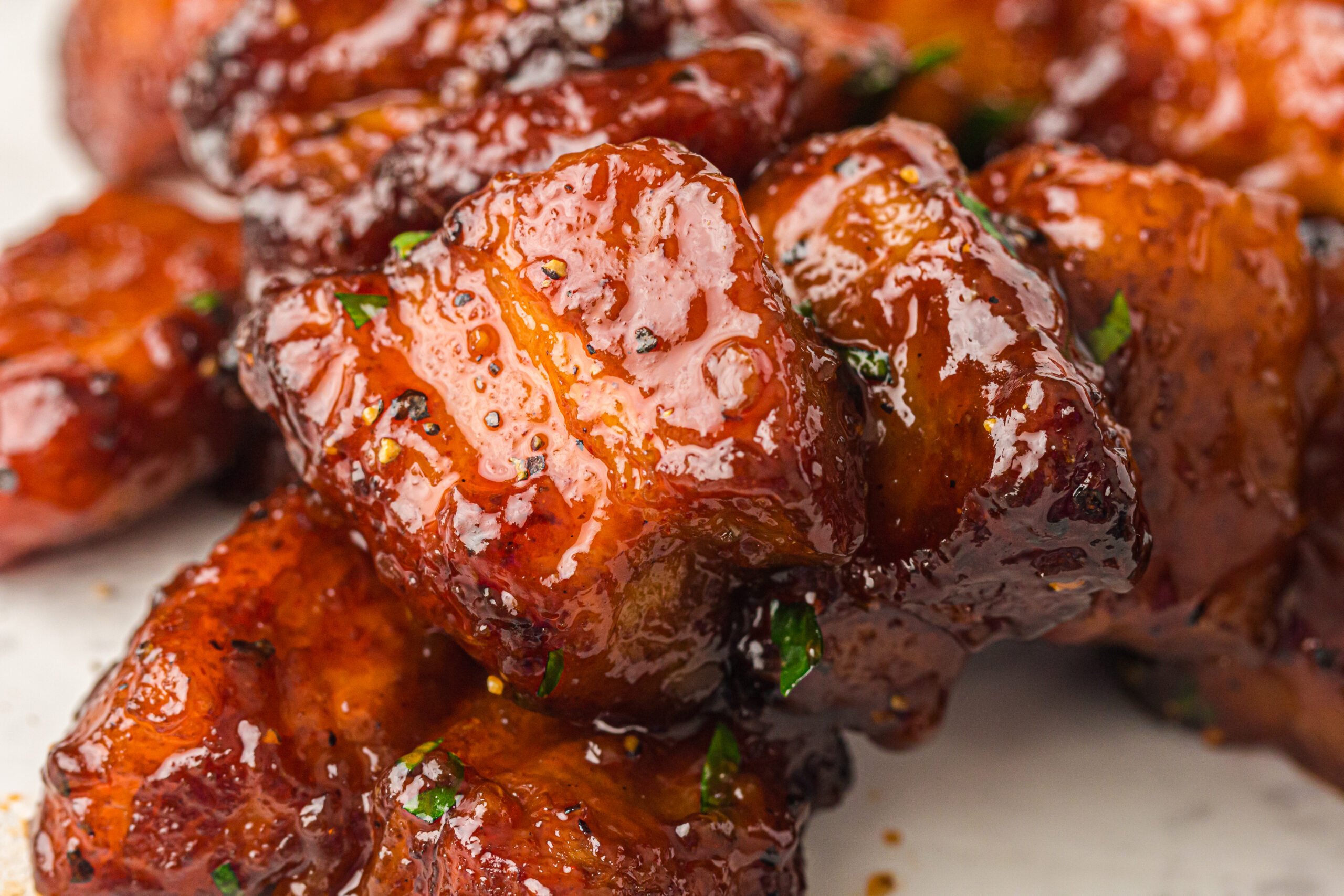 close up view of Smoked Pork Belly Burnt Ends covered in glaze