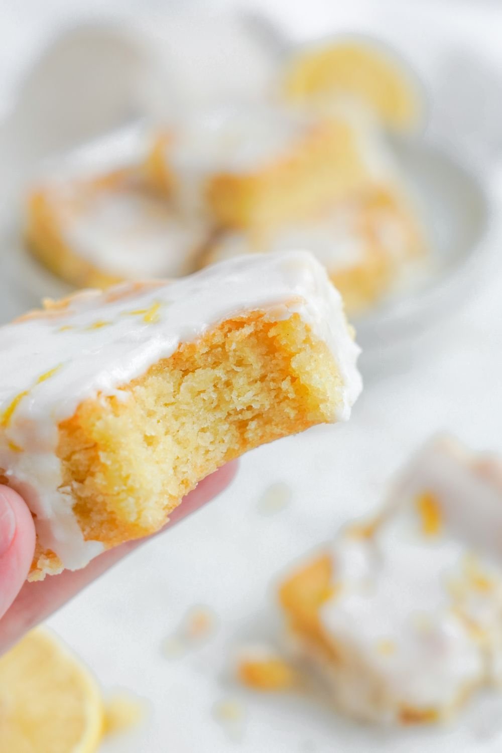 Lemon Sugar Cookie Bar being held in hand with a bite taken out of it 