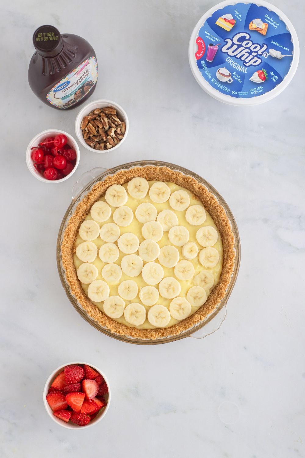 sliced bananas on top of a banana pudding in pie 