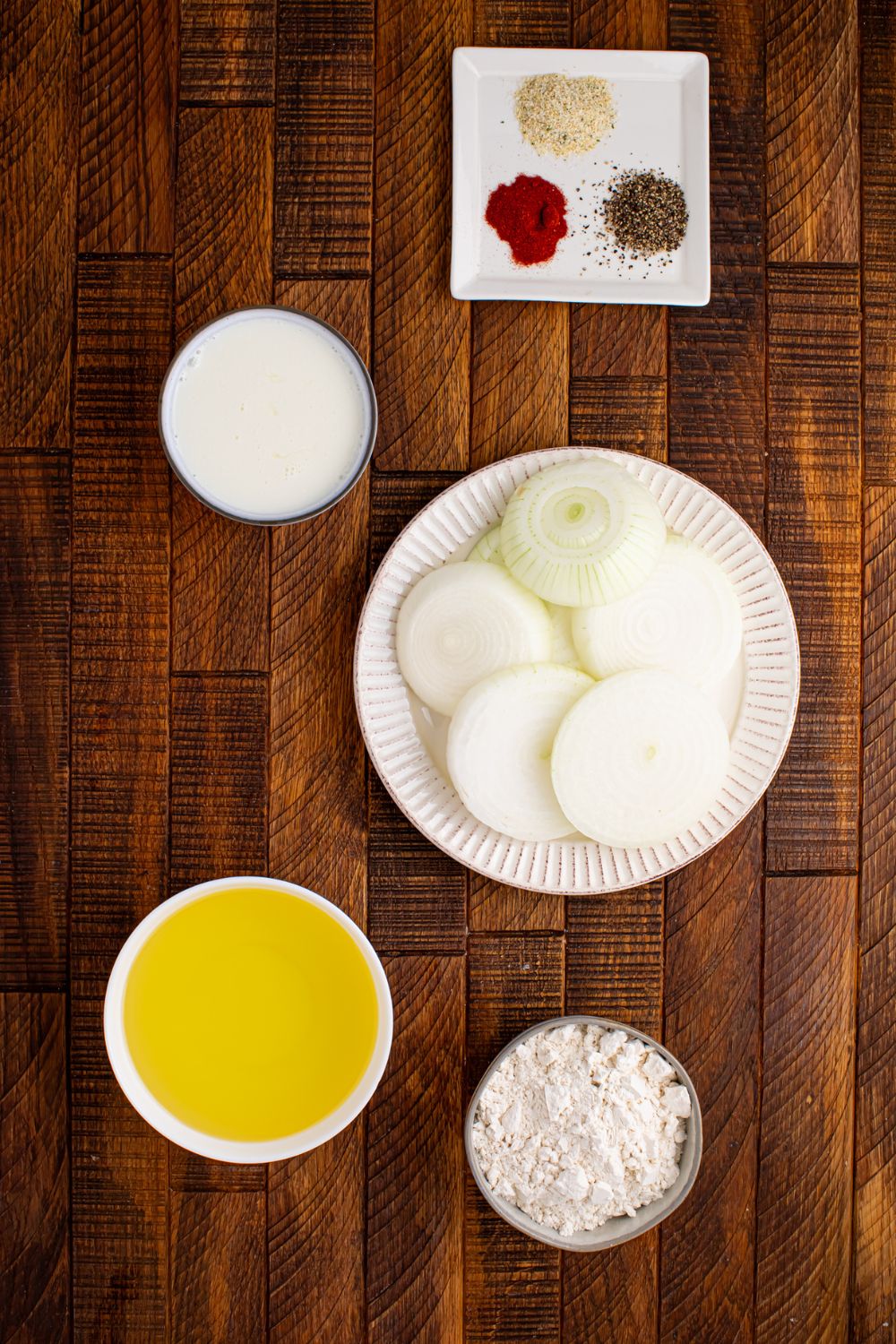 ingredients for Homemade Deep Fried Onion Rings sitting on table in single serve bowls 