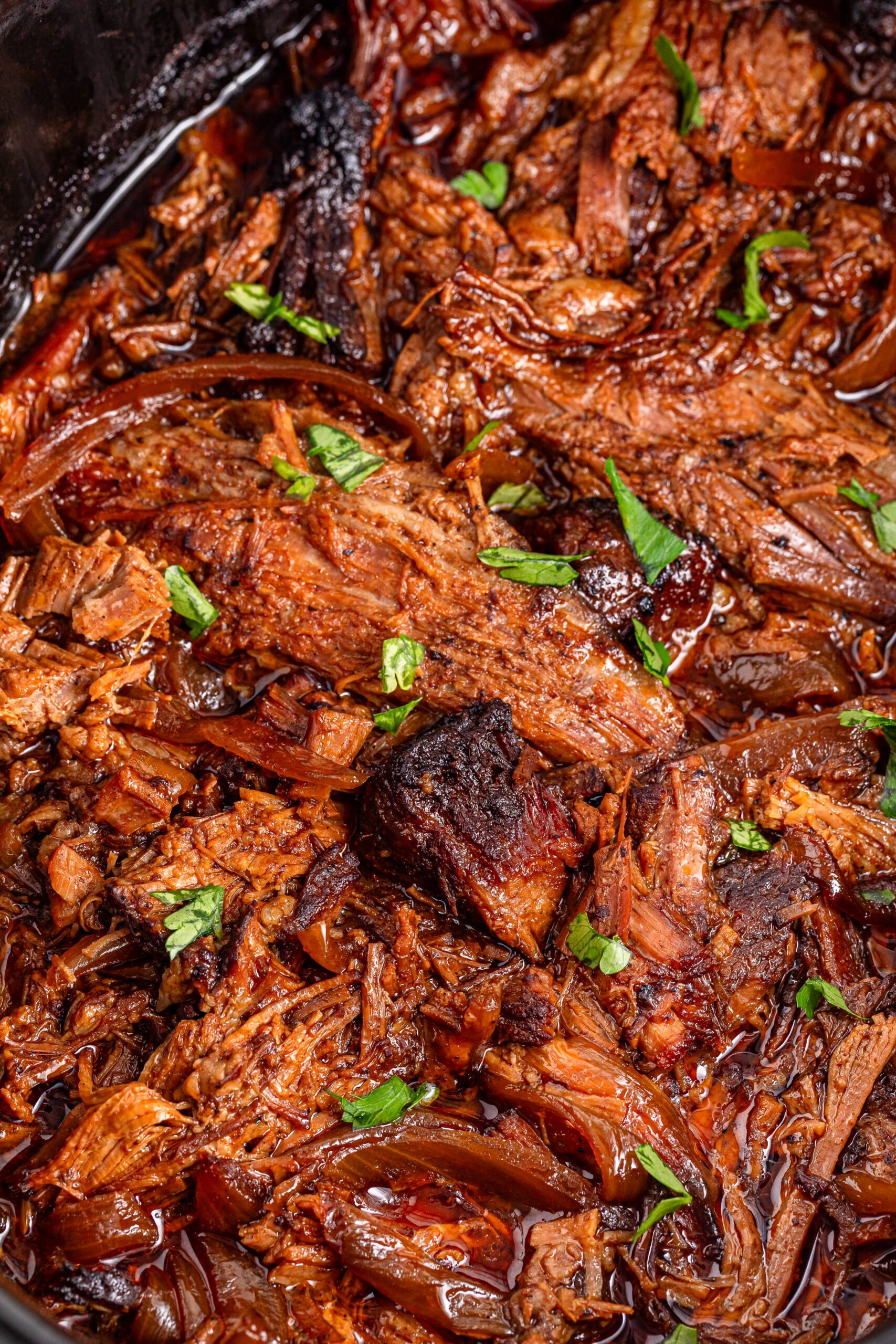 brisket in a black slow cooker up close 