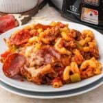 Pizza Casserole on a plate with slow cooker behind it