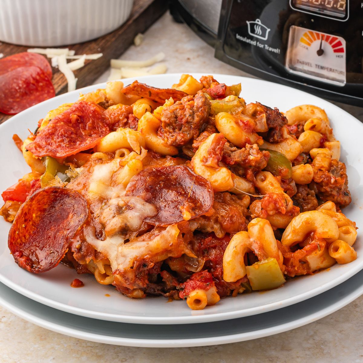 Pizza Casserole on a plate with slow cooker behind it 