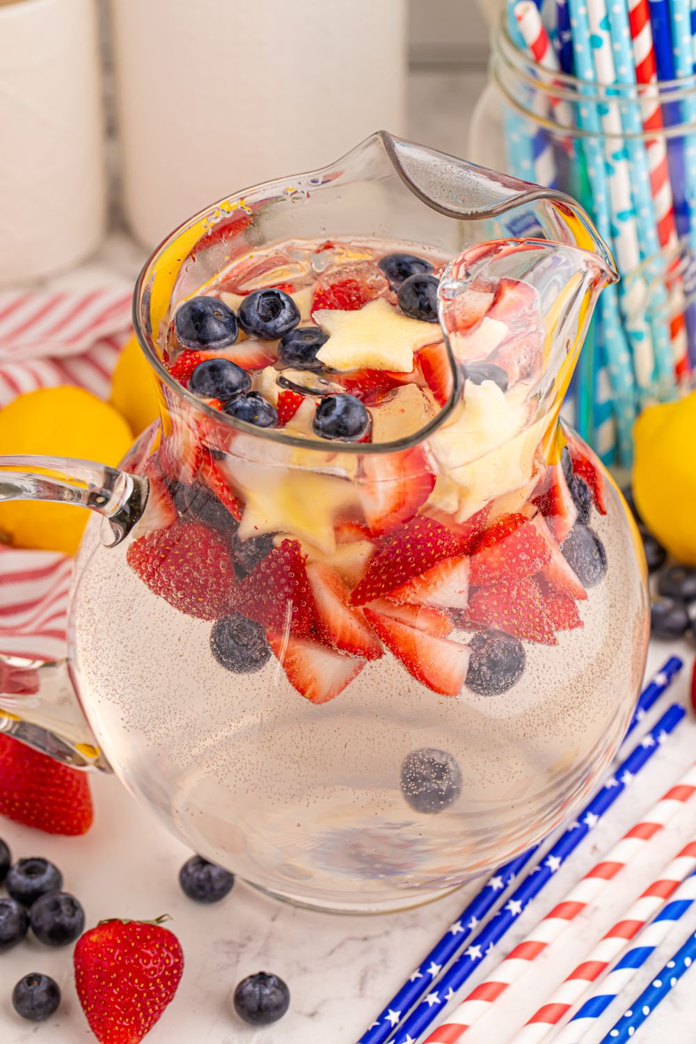 Patriotic Sparkling Lemonade in a pitcher on table with more red white and blue items to showcase the colors 