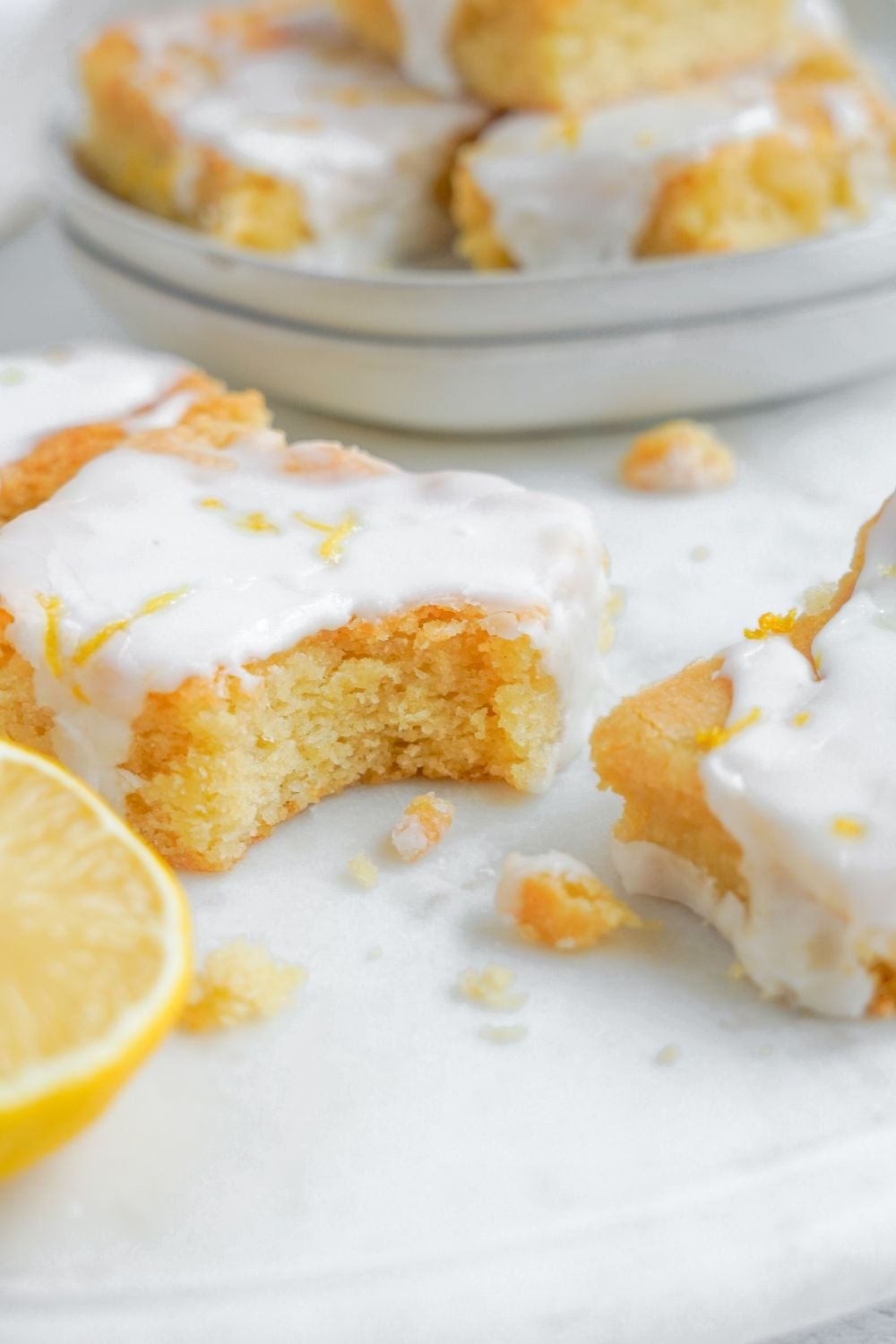Soft and chewy lemon bars sliced and placed on table with a bite taken out of one of the bars