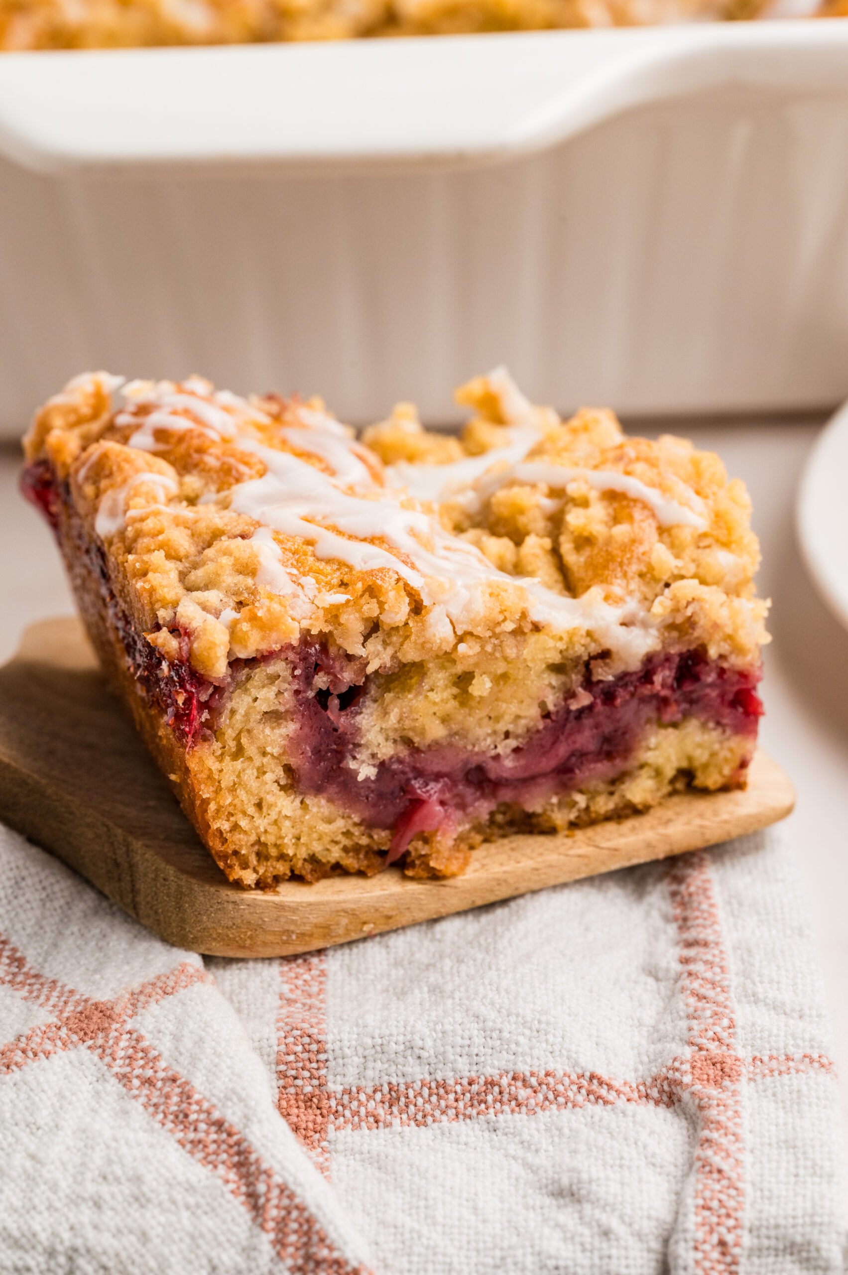 Strawberry Coffee Cake on a wooden spatula sitting on a table 