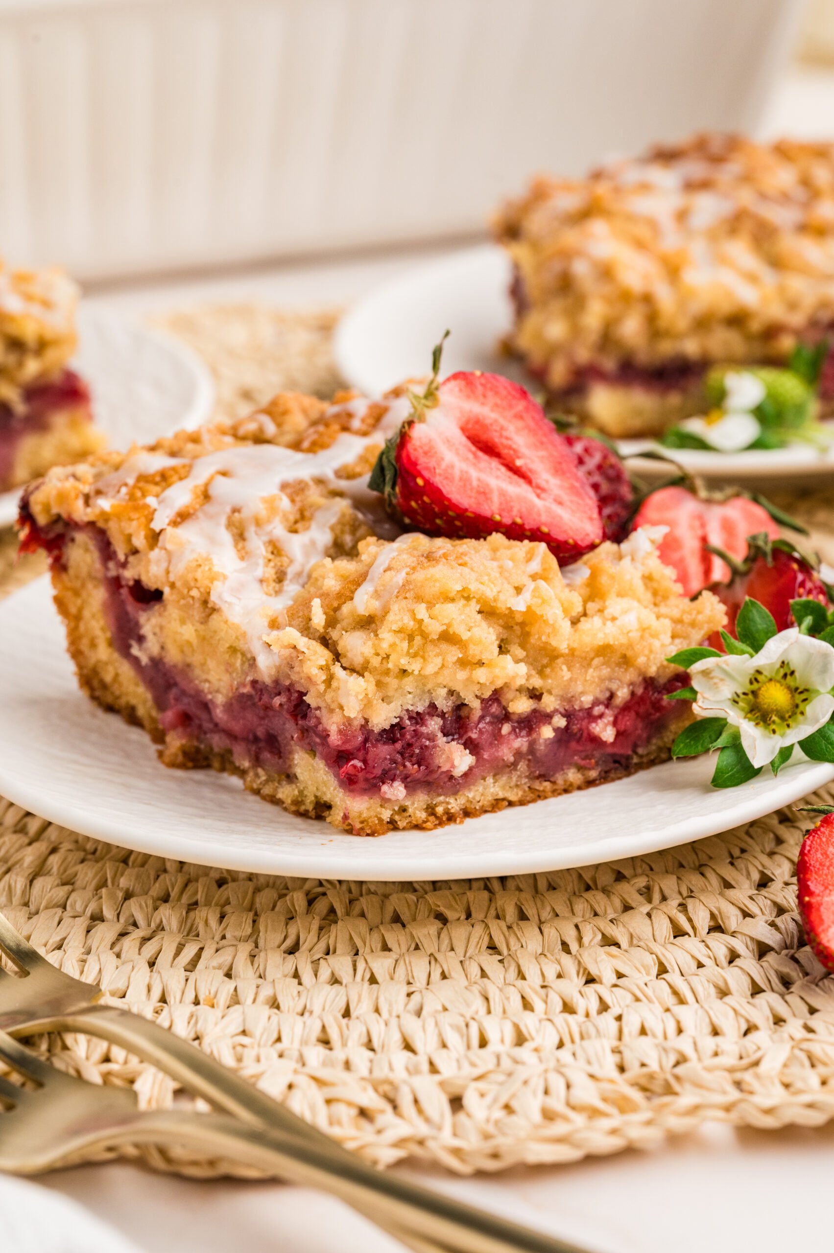 up close shot of the Strawberry Coffee Cake on a white plate with sliced strawberries 
