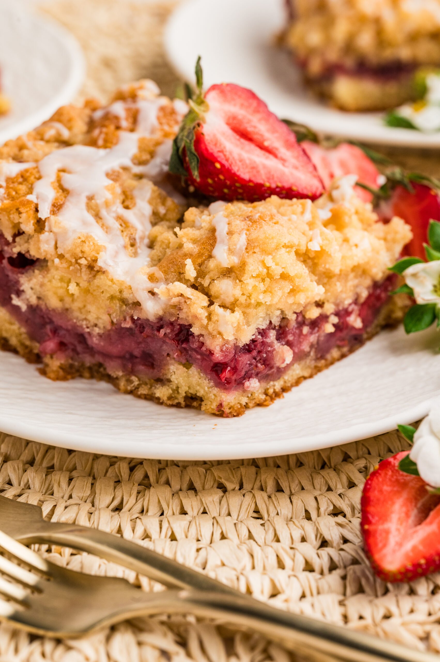 Strawberry Coffee Cake on a white plate with sliced strawberries 