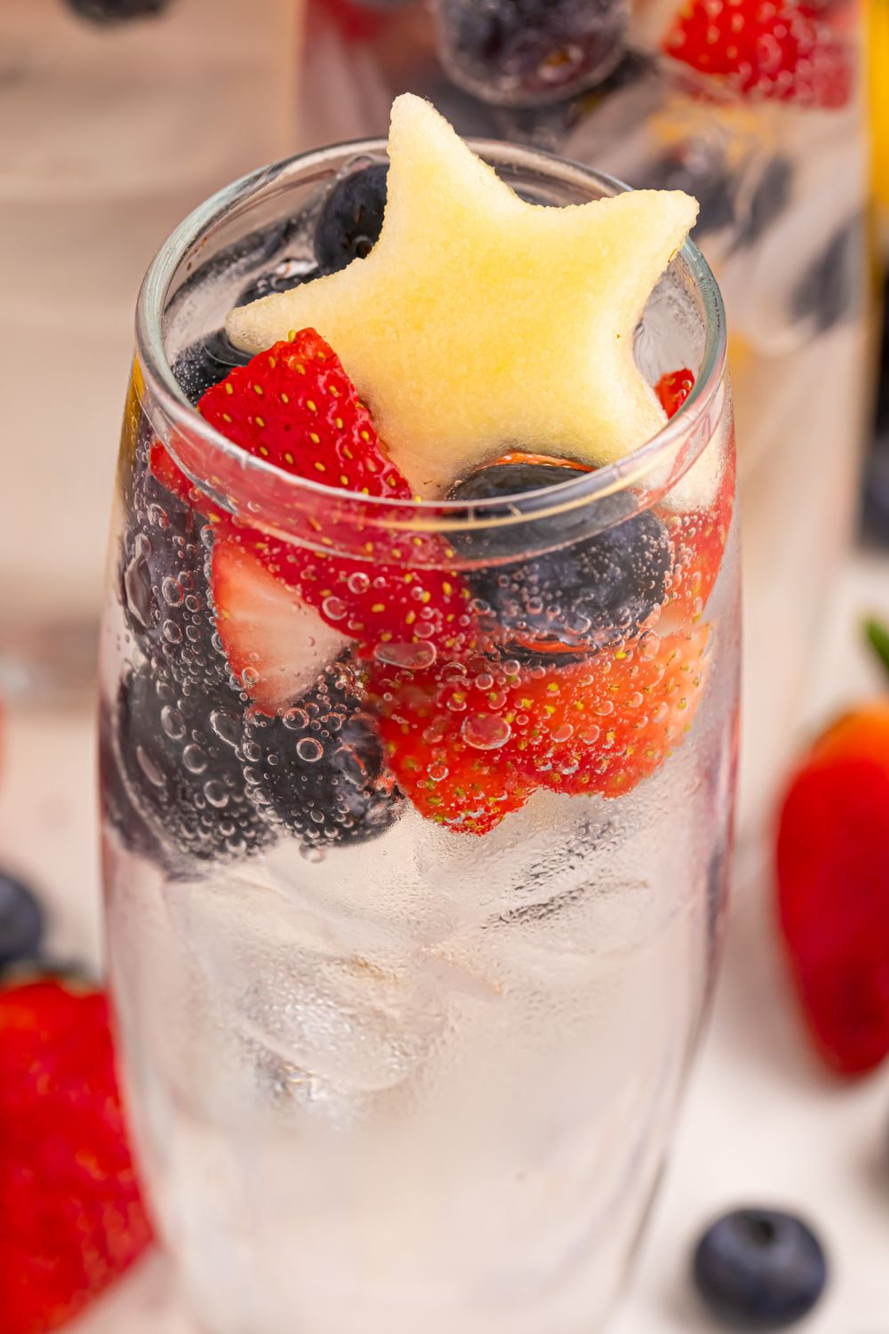 glass with Patriotic Sparkling Lemonade and fruit on top of glass 