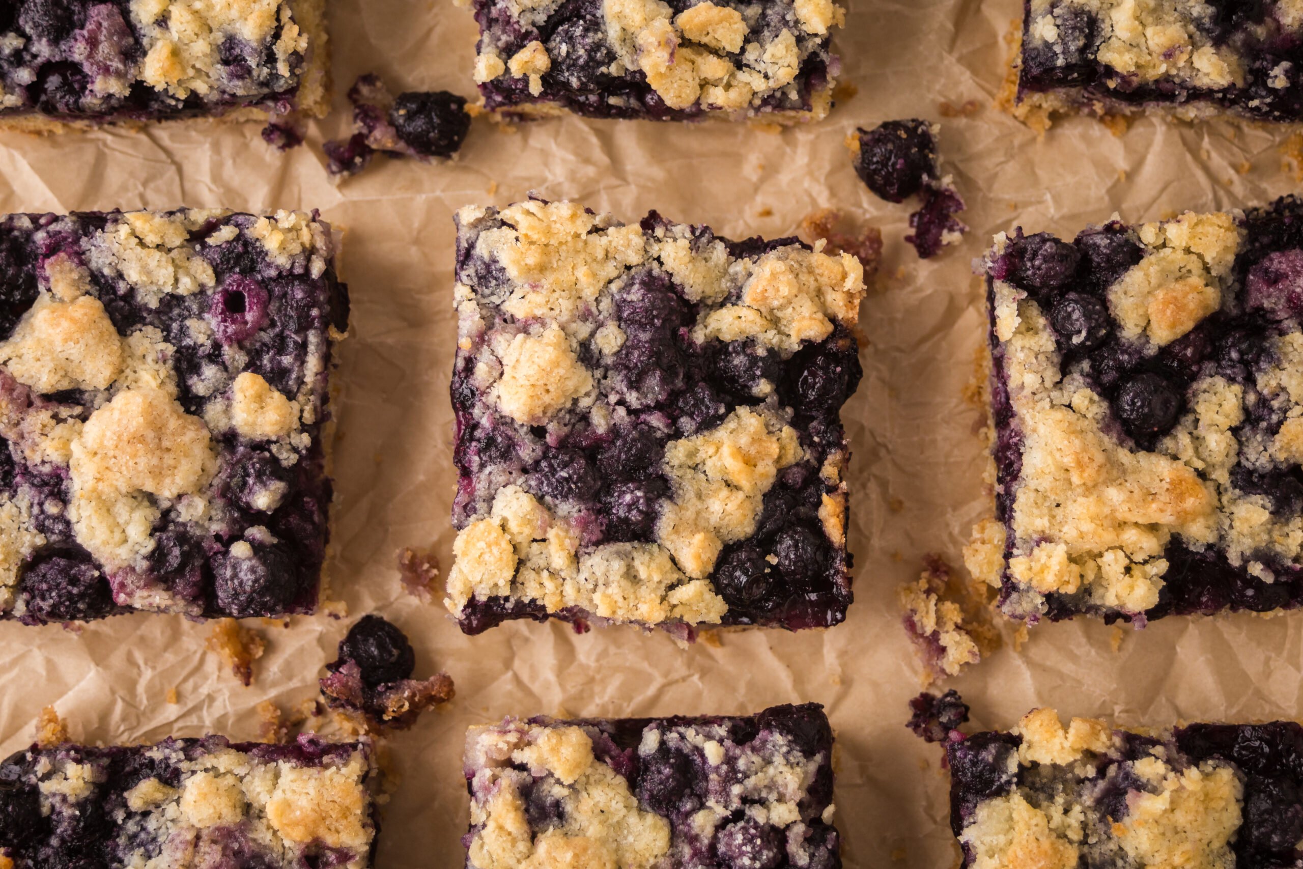 blueberry crumble bars on table all neatly cut into squares