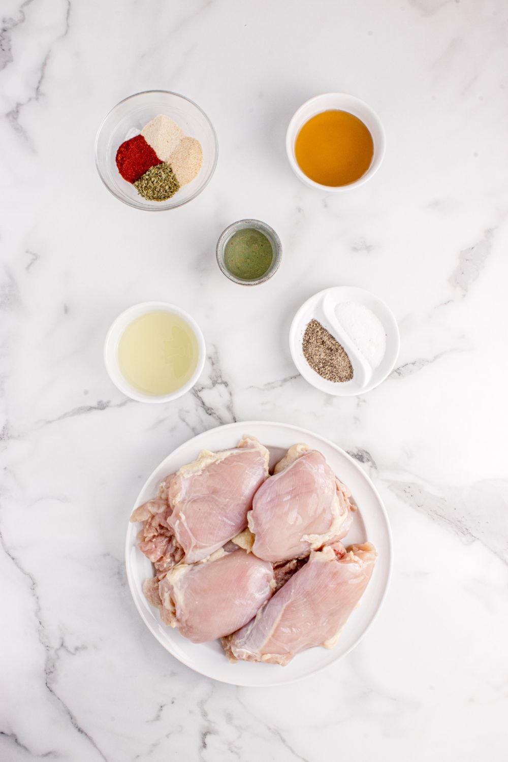 chicken in bowl with spices in single serve bowls around table