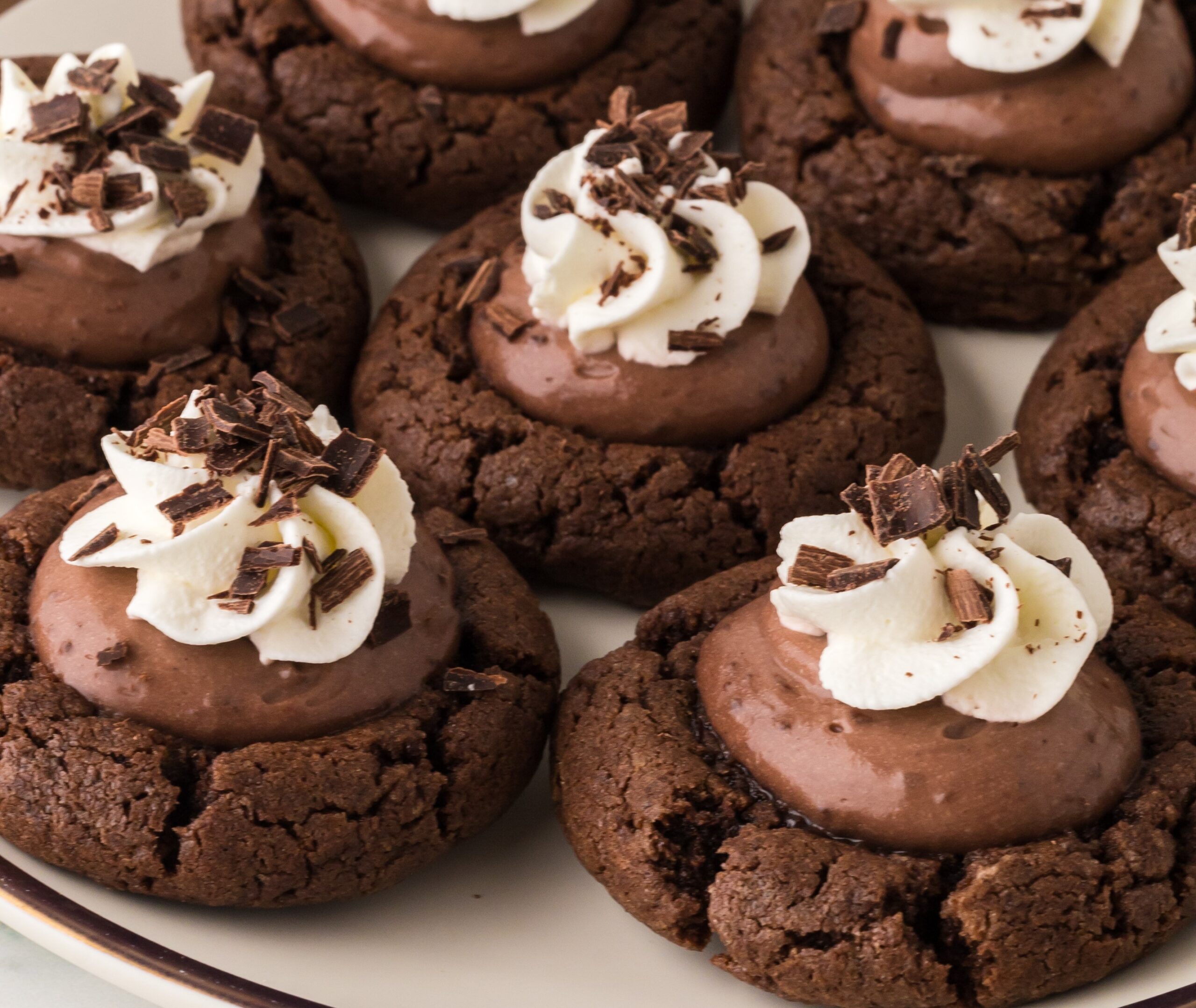 Chocolate Pie Cookies on a white plate topped with whipped cream and chocolate shavings 