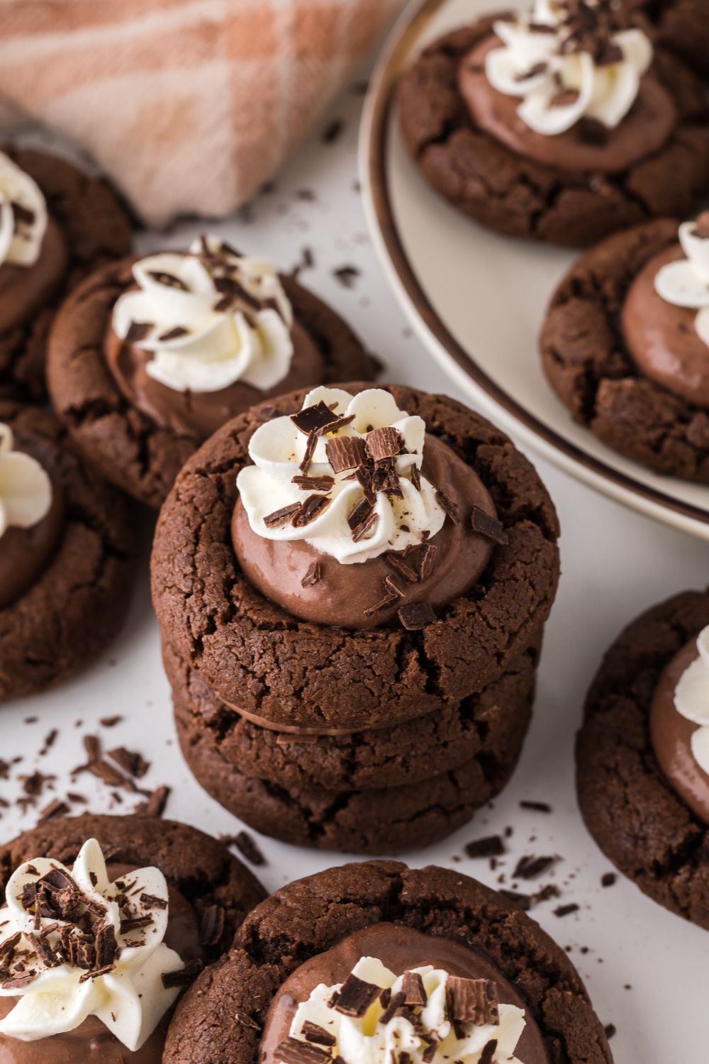 Chocolate Pie Cookies stacked on table with other cookies scattered on table 
