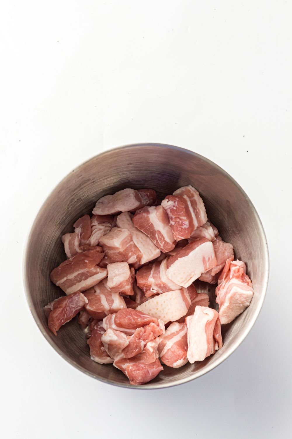 bowl of diced pork belly on table 