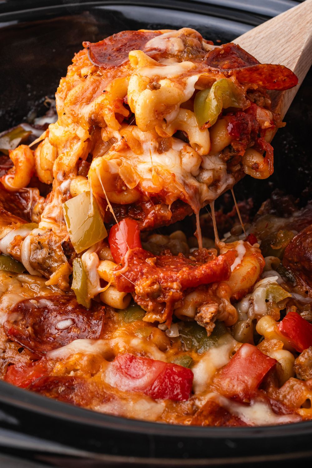 Slow Cooker Pizza Casserole being scooped out of slow cooker 