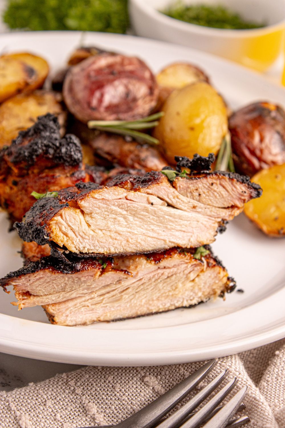 sliced Grilled Chicken Thighs on a plate to show the juicy meat