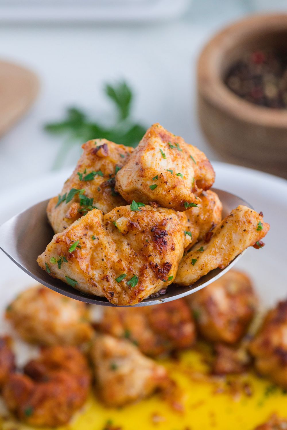 spoon of diced chicken above the skillet
