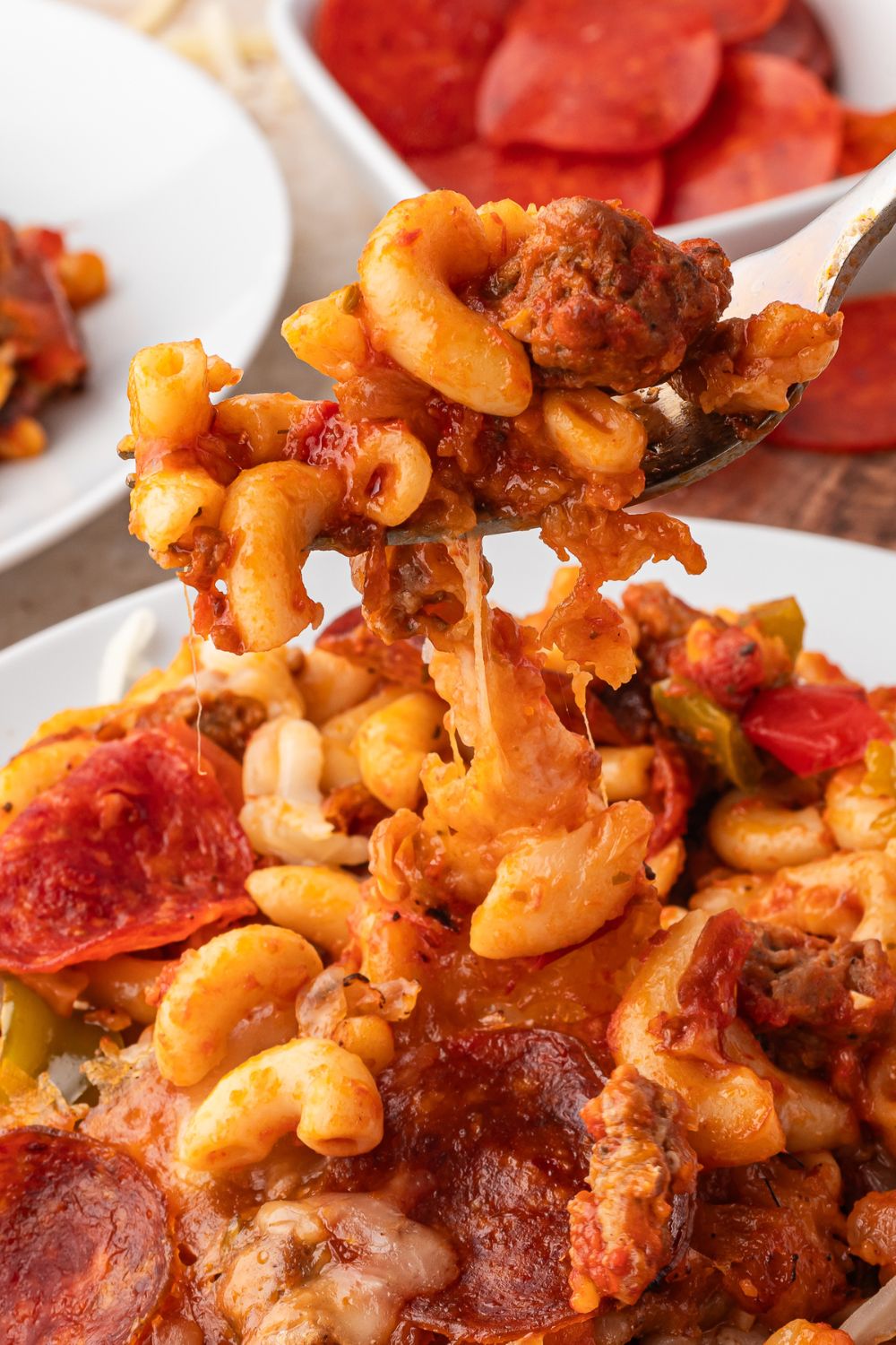 pizza casserole being scooped up with a fork off plate 