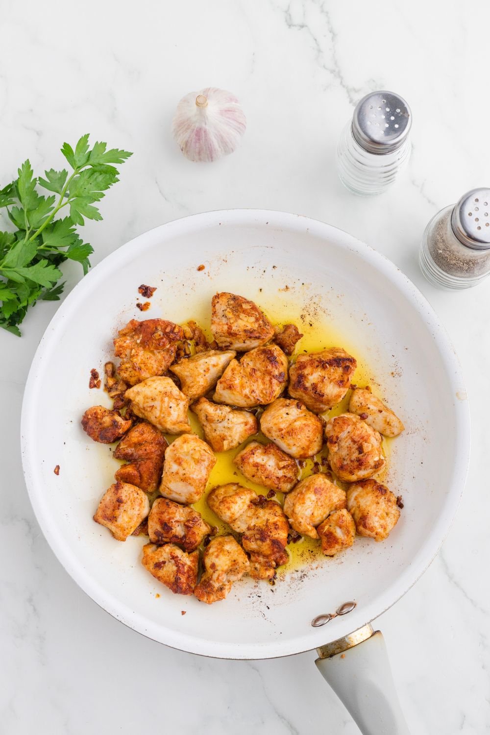 skillet with cooked Garlic Butter Chicken Bites in it 