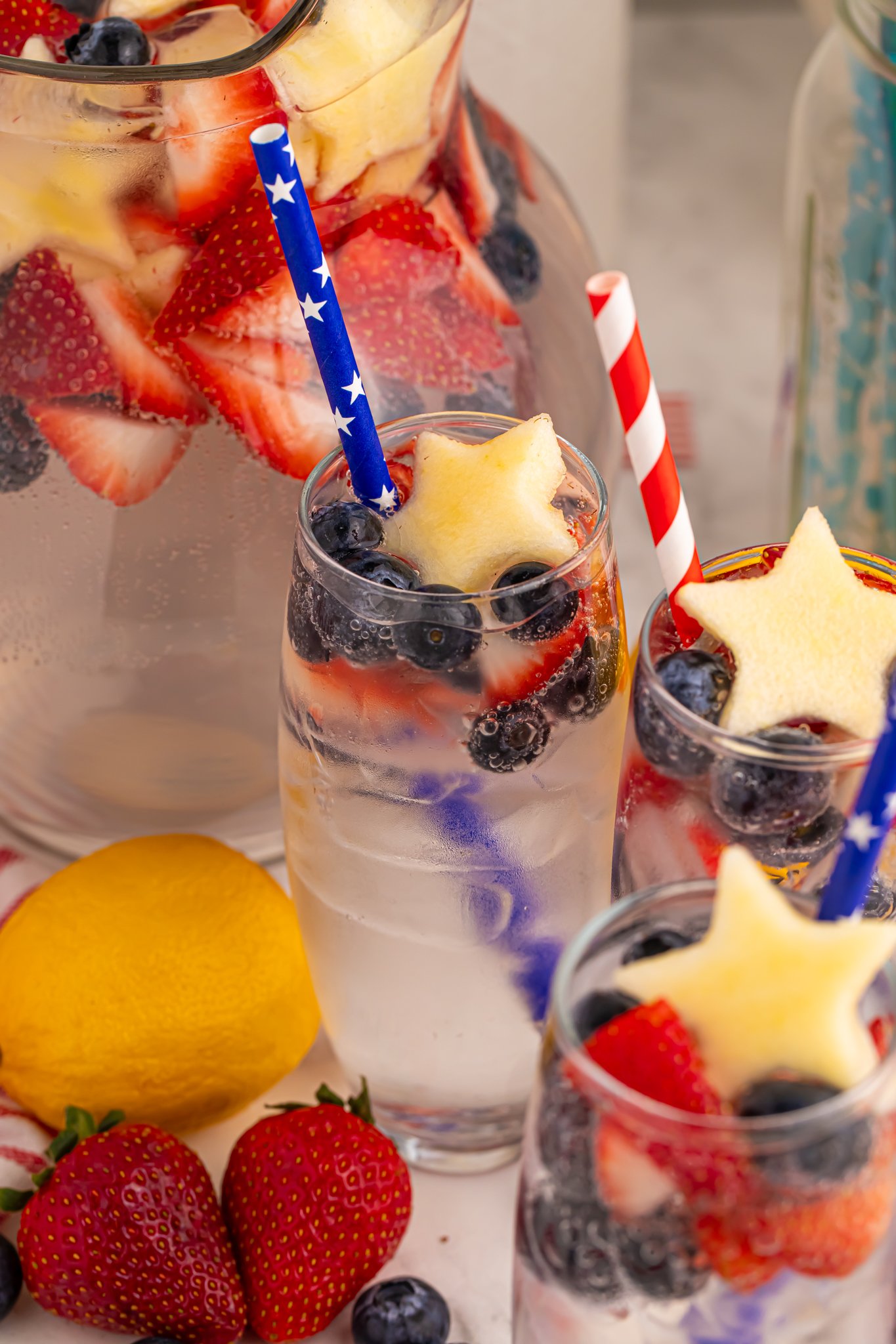 up close shot of the Patriotic Sparkling Lemonade in glasses with fruit scattered on table