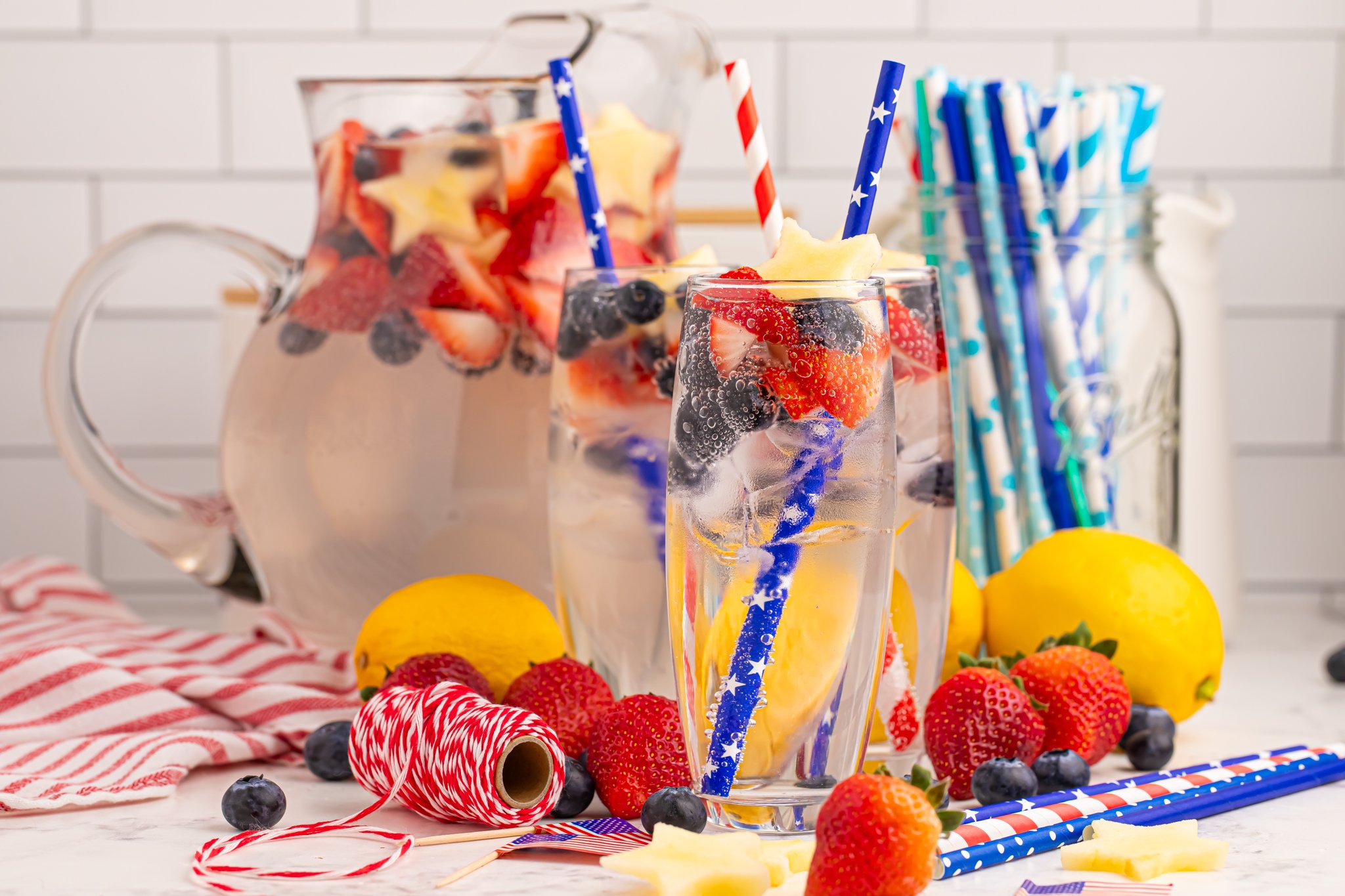 Patriotic Sparkling Lemonade in glasses with fruit scattered on table to add a pop of color 