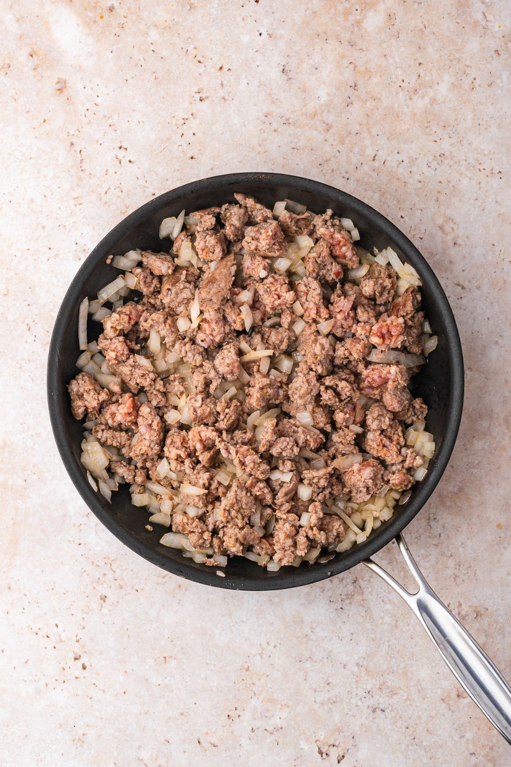 skillet with cooked hamburger and onions in skillet